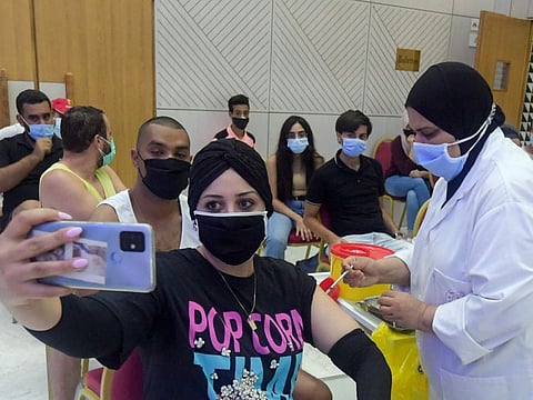 A Tunisian woman takes a selfie as she receives a dose of Sinopharm vaccines in Tunis on July 20, 2021. 