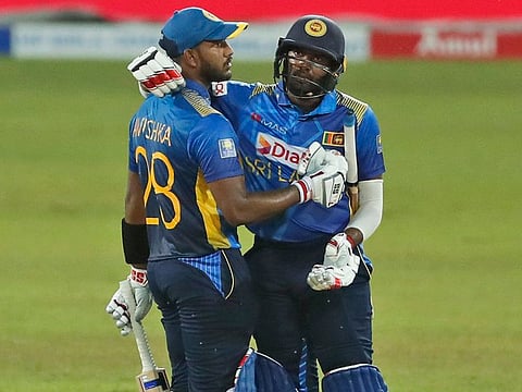 Sri Lanka's Bhanuka Rajapaksa (right) congratulates Avishka Fernando on the latter scoring a half-century during the third One day International against India in Colombo on Friday.