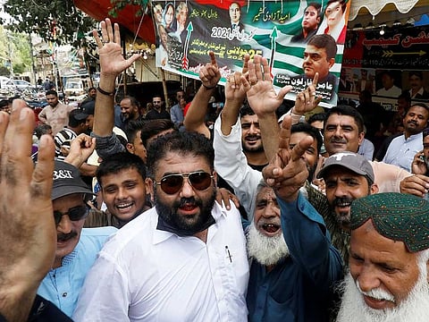 Supporters of political parties chant slogans outside a polling station during voting to elect lawmakers for legislative assembly in Kashmir, Pakistan, July 25, 2021. 