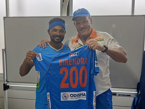 Birendra Lakra (left), veteran India defender, being handed a souvenir shirt on his 200th international appearance by Chief Coach Graham Reid on Tuesday. Amit Rohidas, Lakra's teammate, earned his 100th cap today and was also honoured by the team management.