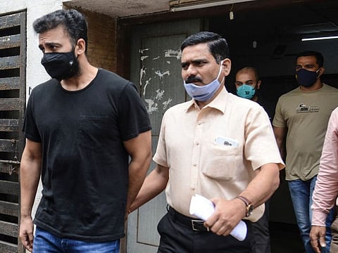 Mumbai Police's Crime Branch team escort Bollywood actress Shilpa Shetty's husband Raj Kundra (L) for allegedly producing and broadcasting pornographic films online, in Mumbai on July 27, 2021.