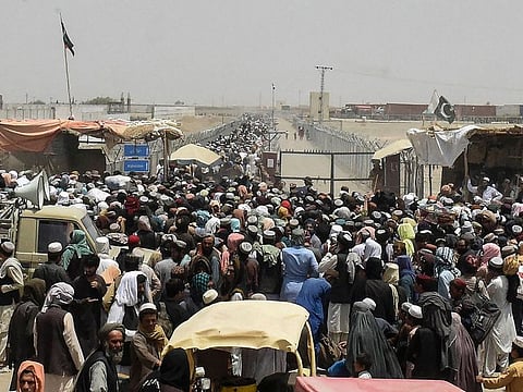 People gather at a border crossing point in Pakistan's border town of Chaman on July 17, 2021, after Pakistan partially reopened its southern crossing with Afghanistan, shut off since the Taliban seized control of the strategic border town on the other side.
