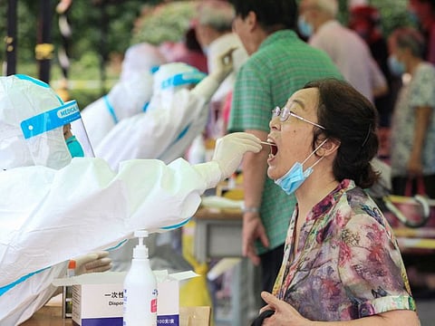 A woman gets tested for the coronavirus in Nanjing, in eastern Jiangsu province on July 29, 2021.  More than 200 cases have been linked to a Delta cluster in Nanjing city where nine cleaners at an international airport tested positive, with the outbreak spanning Beijing, Chongqing and five provinces as of Saturday.