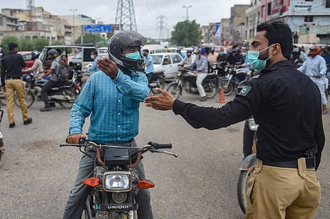 Police diverts traffic as a partial lockdown is imposed to curb the spread of coronavirus in Karachi on July 31, 2021.  
