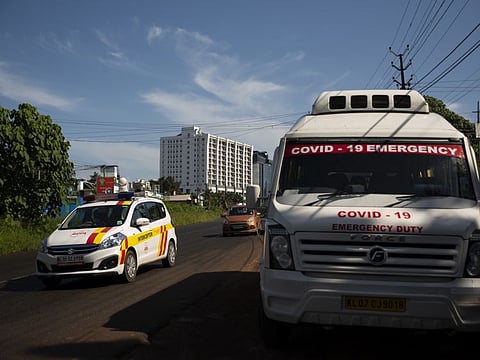 A vehicle used for COVID-19 emergency is parked on a roadside as other vehicles drive past during a weekend lockdown to curb the spread of coronavirus in Kochi, Kerala, on July 31, 2021. 