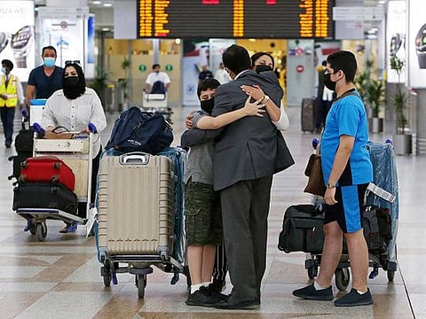 A man greets his family upon their arrival at Kuwait international airport on August 1, 2021, as the authorities allowed entry for fully vaccinated expats. 