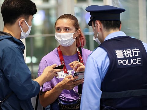 Belarusian athlete Krystsina Tsimanouskaya talks with a police officer at Haneda international airport in Tokyo, Japan August 1, 2021. 