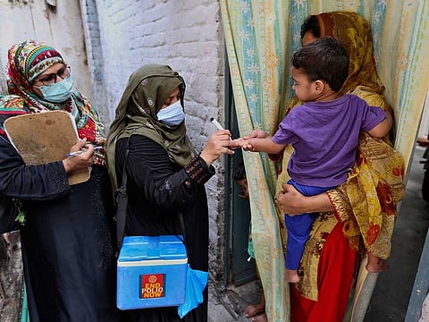 A health worker marks the finger of a child after administrating a polio vaccine in a neighbourhood of Lahore, Pakistan, Monday, Aug. 2, 2021.