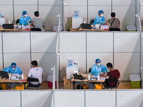 In this photo released by China's Xinhua News Agency, people get COVID-19 vaccinations at a vaccination site at a sports arena in Nanjing in eastern China's Jiangsu Province, Monday, Aug. 2, 2021. Chinese authorities announced Tuesday mass coronavirus testing in Wuhan as an unusually wide series of COVID-19 outbreaks reached the city where the disease was first detected in late 2019. 