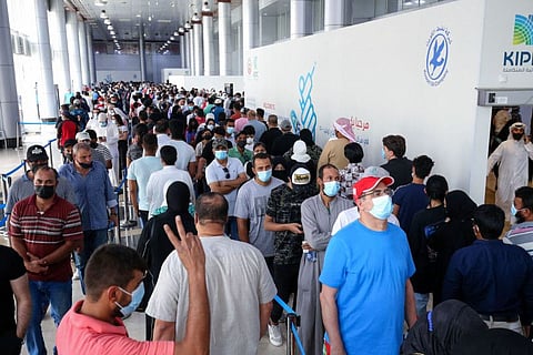 People queue to receive a dose of the COVID-19 vaccine at an inoculation centre in Kuwait City, on August 3, 2021.  