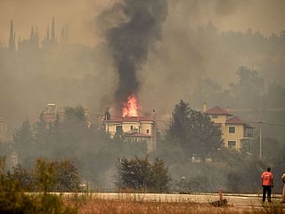Photos: Thousands flee as wildfires rage through Greece