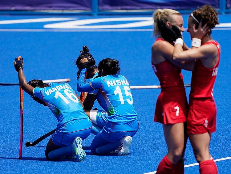 India's Vandana Katariya (16) and India's Nisha (15) kneel