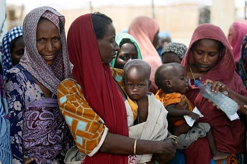 Women wait with their children under a shed for food rations at a internally displaced persons (IDP) camp on the outskirts of Maiduguri, northeast Nigeria, in a file photo.