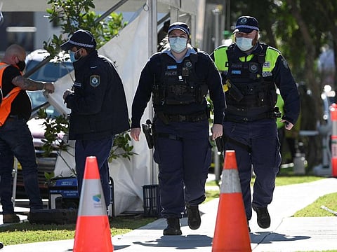 Police walk outside a residential building in the southwestern Sydney suburb of Campbelltown, after residents were placed in isolation due to reports of COVID-19 infections within the building. 
