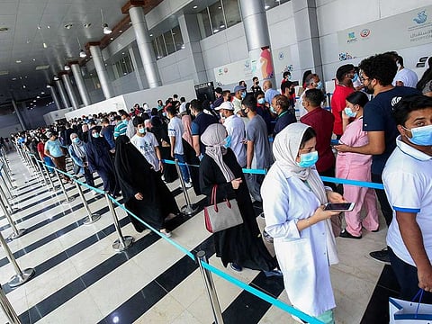 People queue to receive a dose of the COVID-19 vaccine at an inoculation centre in Kuwait City, on August 3, 2021. 