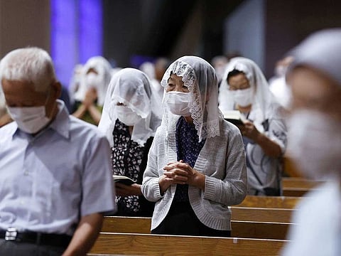 Local residents wearing protective masks pray for victims of the 1945 atomic bombing during a mass at the Urakami Cathedral in Nagasaki, Japan, August 9, 2021, on the 76th anniversary of the bombing of Nagasaki, in this photo taken by Kyodo. 