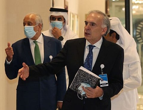 US special envoy for Afghanistan Zalmay Khalilzad (left) and the United Nations Secretary General's personal envoy on Afghanistan Jean Arnault walk down a hotel lobby in Qatar's capital Doha during an international meeting on the escalating conflict in Afghanistan, on August 10, 2021. 