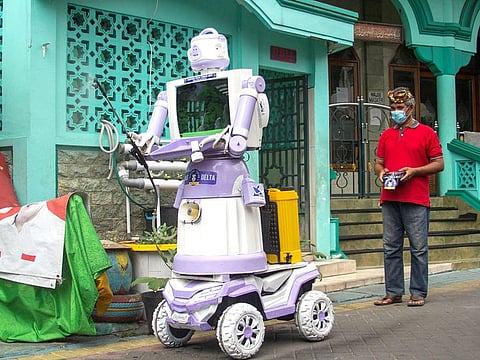 Aseyanto, 53, a resident of the Tembok Gede neighbourhood, operates the "Delta Robot", made from household items like pots, pans and an old television monitor, in Surabaya, East Java province, Indonesia.