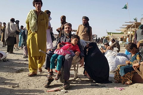 Stranded people wait for the reopening of the Pakistan-Afghanistan border crossing point which was closed by the authorities, in Chaman on August 12, 2021, after the Taliban took control of the Afghan border town in a rapid offensive across the country.  
