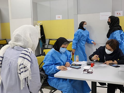 Medical personnel work in a vaccination centre as COVID-19 cases spike, in Tehran, on August 9, 2021. Medical personnel who were once afraid to speak out are now openly chastising what many Iranians see as gross misjudgment, incompetence and negligence in the nation’s leadership, from Supreme Leader Ayatollah Ali Khamenei on down.