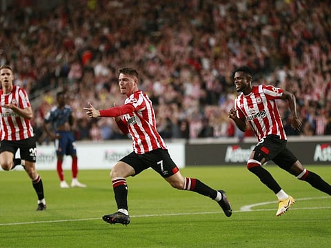 Brentford's Sergi Canos celebrates after scoring the opening goal during the English Premier League match against Arsenal at the Brentford Community Stadium in London, England. Brentford won 2-0 in their first Premier League match ever, as fans returned to the stadiums without restrictions on numbers since the start of the COVID-19 pandemic.