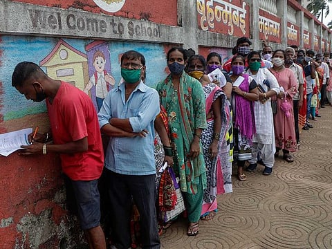 People line up to get inoculated against COVID-19 outside a vaccination center in Mumbai. 