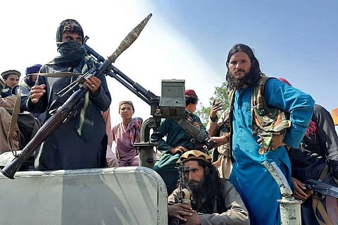 Taliban fighters in a vehicle on a street in Laghman province on August 15, 2021.