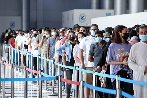 People queue up to receive a dose of the COVID-19 vaccine at an inoculation centre in Kuwait City.