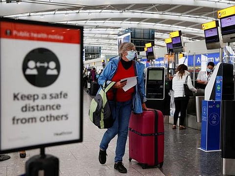 A passenger walks with her luggage at the Terminal 5 departures area at Heathrow Airport in London, Britain.