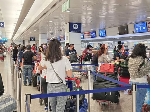 Filipinos queue up to check in for the Dubai-Manila flight at Dubai International Airport on Thursday. 