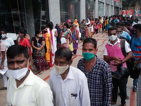 People wait in a queue to receive the vaccine outside a shopping mall in Mumbai.