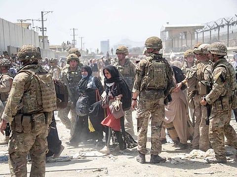 In this photo provided by the Ministry of Defence, members of the British and US military engage in the evacuation of people out of Kabul, Afghanistan on Friday, August 20, 2021. 