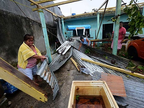 People pick up roofing sheets after Hurricane Grace slammed into the coast with torrential rains, in Tecolutla, Mexico August 21, 2021.   