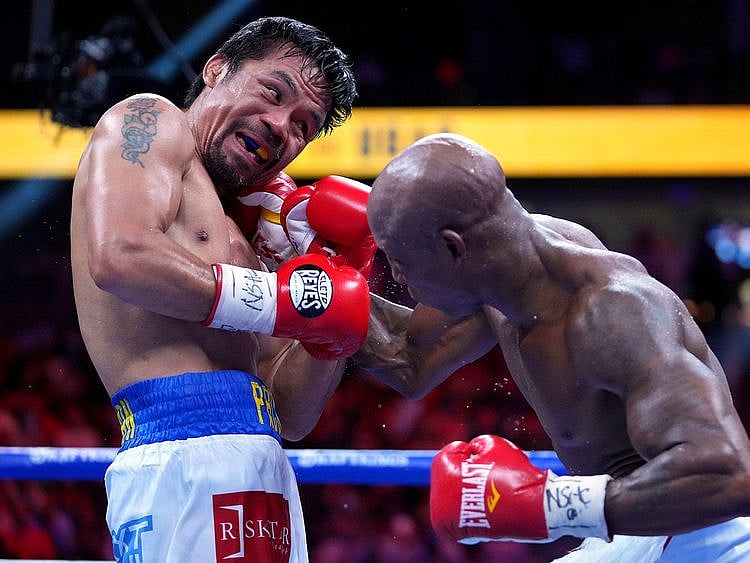 Manny Pacquiao (left) fights Yordenis Ugas in a world welterweight championship bout at T-Mobile Arena