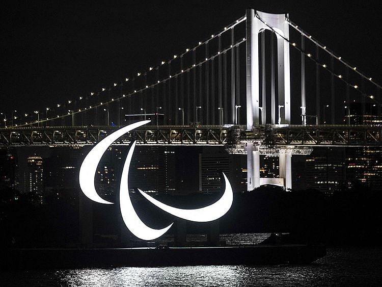 The Paralympics emblem lit up with the Rainbow bridge in the background, on the Odaiba waterfront in Tokyo 