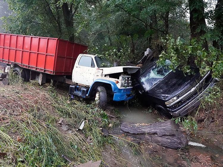 A truck and a car sit in a creek, after they were washed away the day before in McEwen, Tennessee. 
