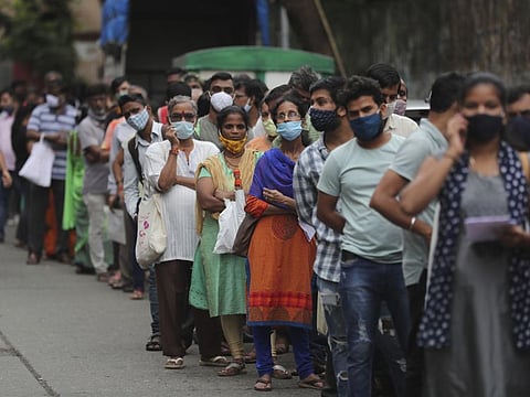 People wait to get inoculated against COVID-19 in Mumbai.