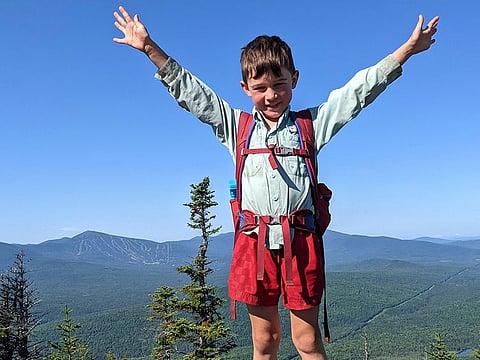 In this July 23, 2021, family photograph provided by Joshua Sutton, 5-year-old Harvey Sutton raises his arms on a mountain top in Bigelow Preserve, Maine, while hiking the Appalachian Trail with his Mom and Dad.