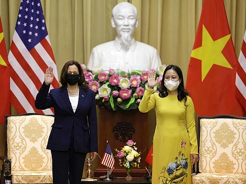 US Vice President Kamala Harris (L) waves beside Vietnam's Vice President Vo Thi Anh Xuan in the Gold room of the Presidential Palace in Hanoi on August 25, 2021.  