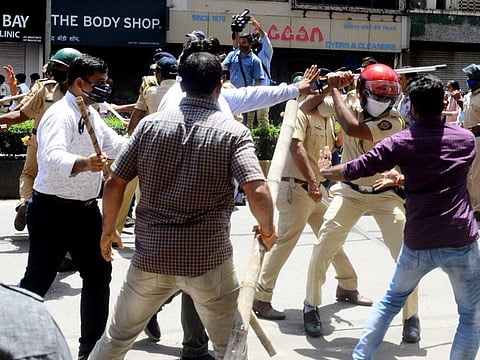 Police personnel wield their batons against the supporters of Shiv Sena and BJP as a clash breaks out between them during a protest march towards Union Minister Narayan Rane's residence after his statement against Maharashtra Chief Minister Uddhav Thackeray, in Mumbai.