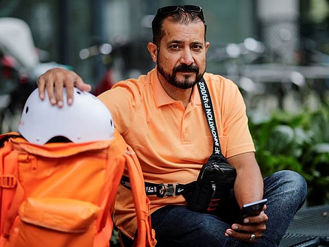 Former Afghan Communication Minister Sayed Sadaat sits with his gear as he works for the food delivery service Lieferando in Leipzig, Germany.