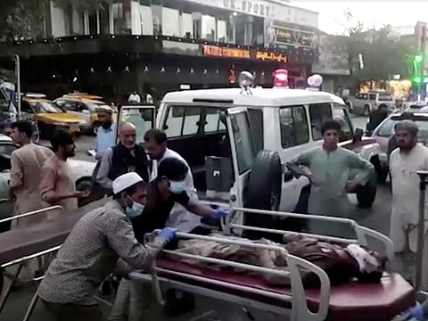 A screen grab shows people carrying an injured person to a hospital after an attack at Kabul airport, in Kabul, Afghanistan August 26, 2021