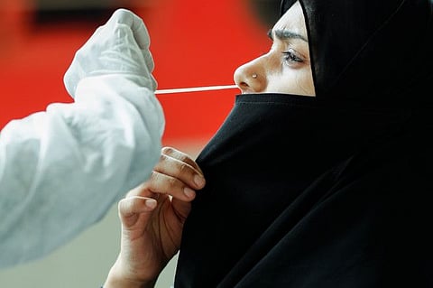 A health worker collects a swab sample from a woman during a rapid antigen testing campaign for COVID-19, at a railway station platform in Mumbai, on August 27, 2021. 