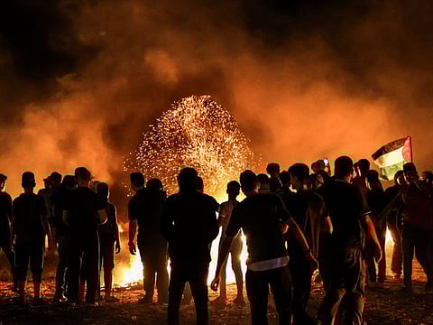 Palestinian protesters burns tyres following a demonstration along the border between the Gaza Strip and Israel east of Gaza City on August 28, 2021. 