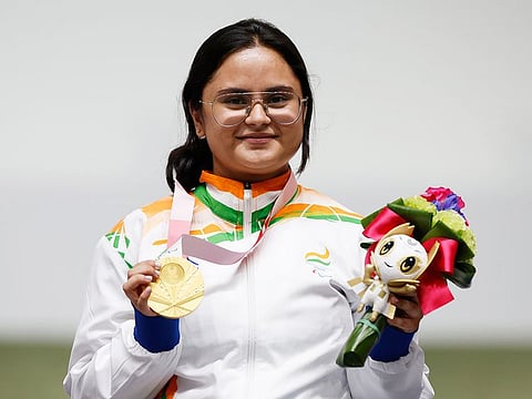 Gold medallist Avani Lekhara of India celebrates on the podium. 