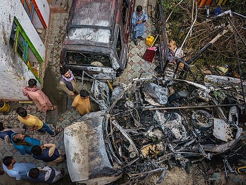 Relatives and neighbours of the Ahmadi family gathered around the incinerated husk of a vehicle that the family says was hit by a US drone strike, killing 10 people, in Kabul, Afghanistan, Monday, August 30, 2021. 
