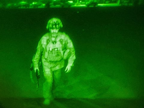 US Army Major General Chris Donahue, commander of the 82nd Airborne Division, steps on board a C-17 transport plane as the last US service member to leave Hamid Karzai International Airport in Kabul, on August 30, 2021 in a photograph taken using night vision optics.  