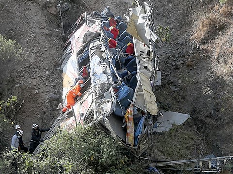 Rescue workers check a bus after it crashed, in Matucana, Peru, on August 31, 2021. 