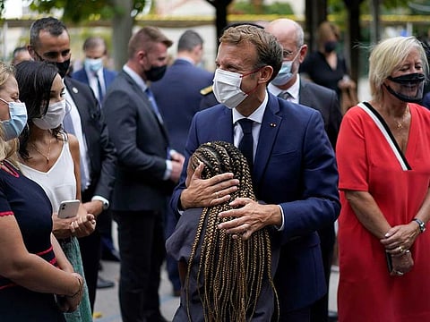 French President Emmanuel Macron hugs a child during a visit at Bouge primary school in Malpasse district of Marseille September 2, 2021 as millions of children in France go back to school Thursday for the new academic year, wearing masks as part of rules aimed at slowing down the spreading of the coronavirus. 
