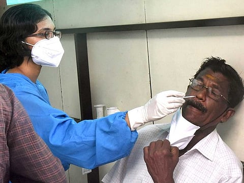 A healthcare worker takes a nasal sample from man for the COVID-19 test, at the Government General Hospital, in Kochi, Kerala on Tuesday, August 31, 2021. 